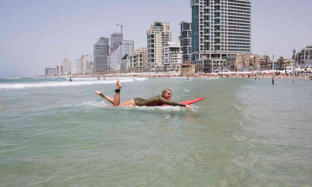 Woman surfing in the Mediterranean Sea near Tel Aviv's beachfront