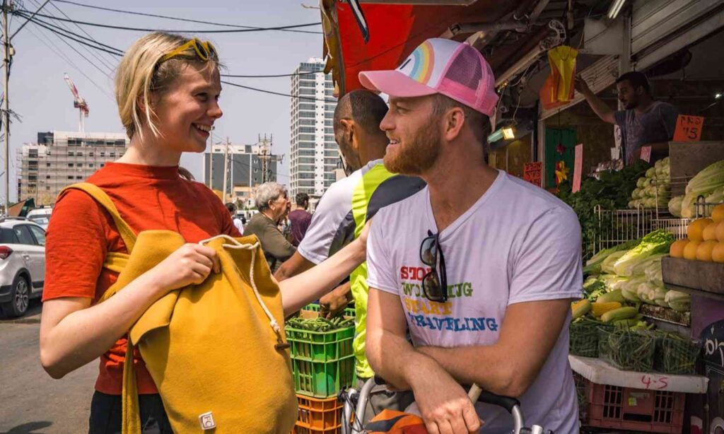 Travelers exploring a local produce market in Tel Aviv